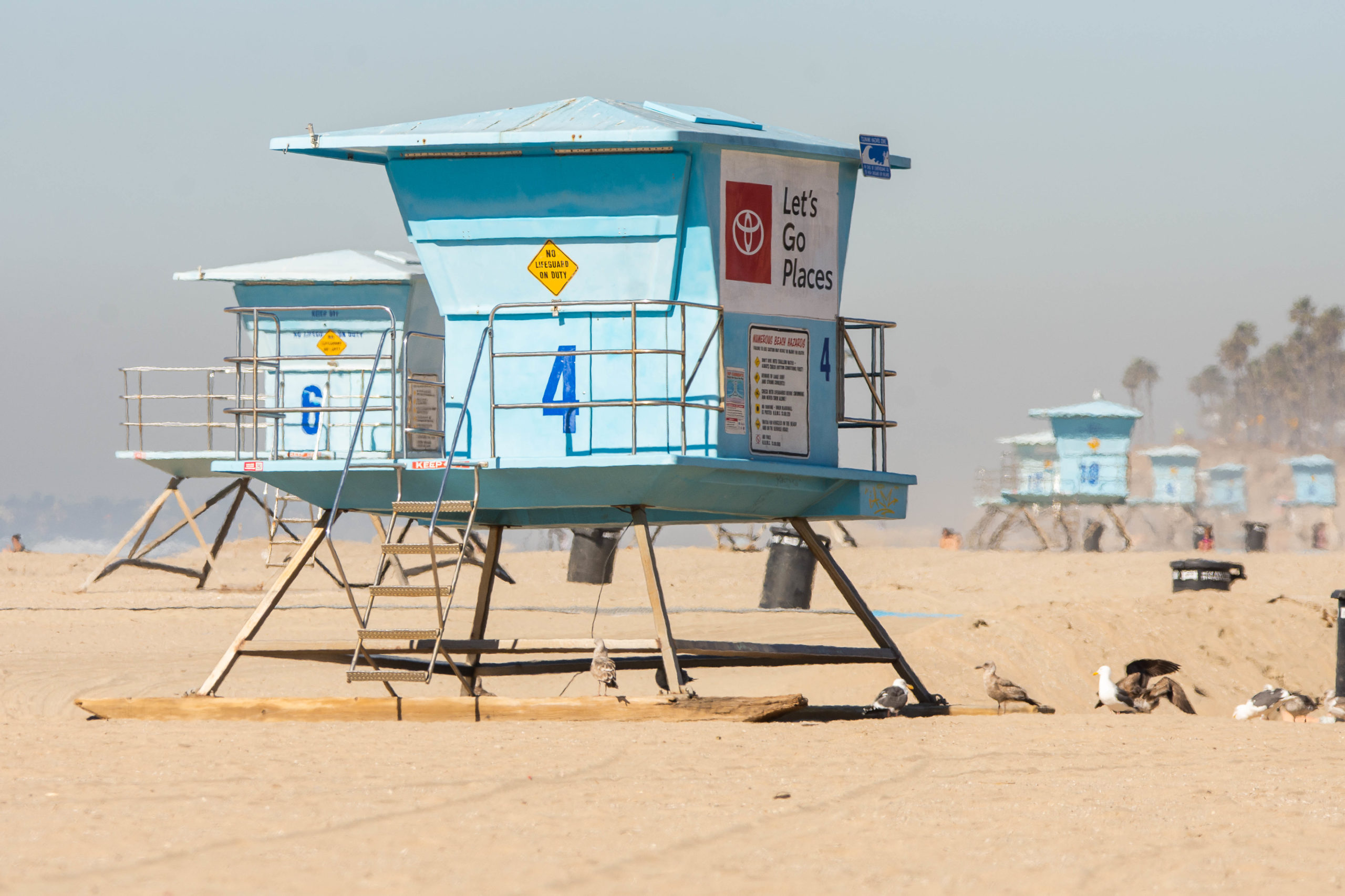 A series of lifeguard towers beginning with number four on the north side of the Huntington Beach Pier.