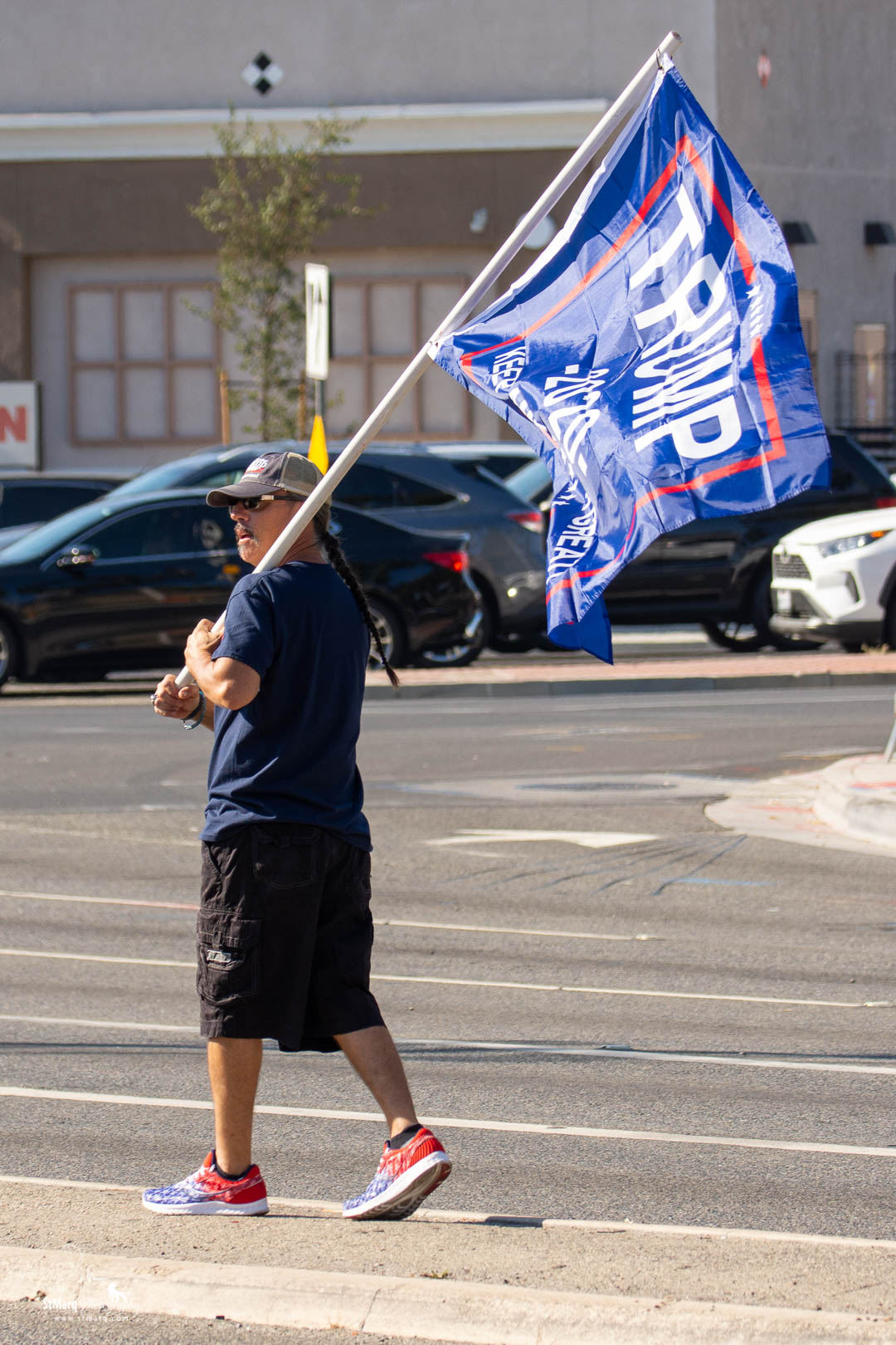 Fernando Castillo walks in the center divider of Imperial Highway with a Trump flag on Sunday, October 18, 2020 at a Rally in support of president Trump in La Habra, California.